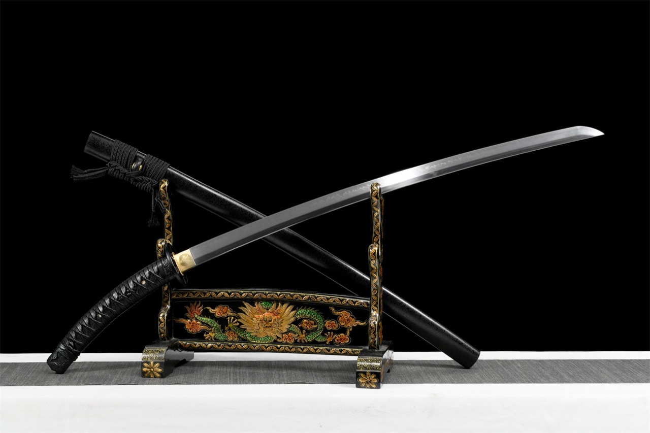 A katana drawn from its black scabbard and laid blade-up across a lacquered stand, the scabbard crossed behind it, against a black field. The stand's rail is painted with a gold-faced dragon in green and orange among clouds.